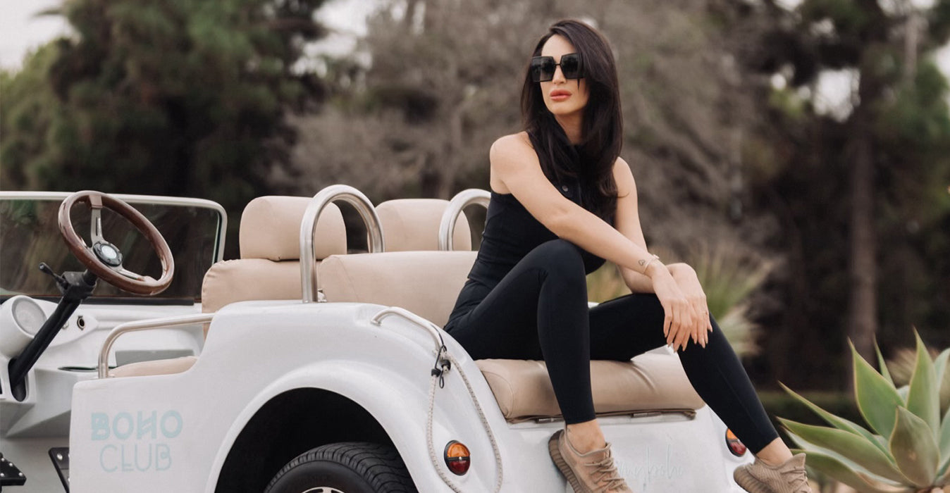 A woman sits on the car.